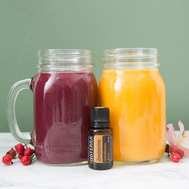 Una botella de zendocrine se coloca junto a tazas de vidrio llenas de batidos de color morado y amarillo sobre un fondo verde pastel.