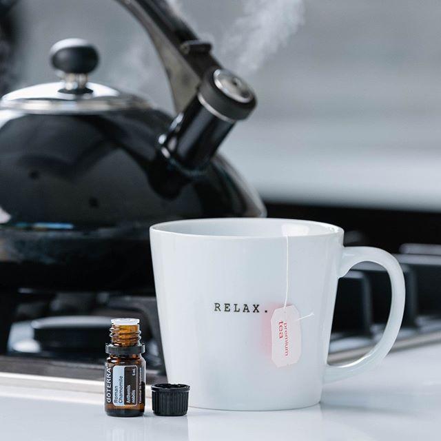 Frasco de aceite esencial en una cocica cerca de un té y una pava