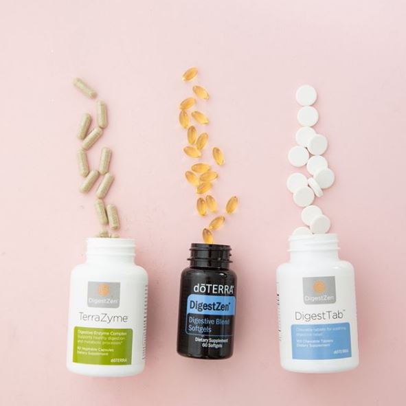 Botellas colocadas de lado con cápsulas cayendo de la botella sobre un fondo rosa neutro.