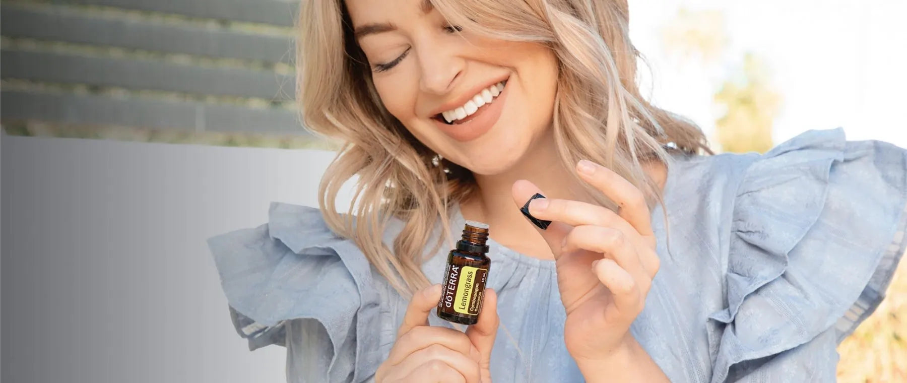 Mujer sonriente usando aceite esencial-lemongrass doTERRA