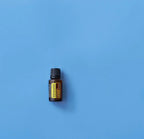 Frasco del Aceite Esencial de Citronela dōTERRA 15ml centrado sobre fondo liso azul cielo, composición minimalista