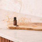 Aceite esencial de clavo dōTERRA 15 ml sobre tabla de madera rústica con flores secas y clavos de especia