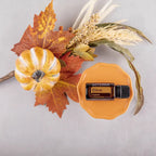Aceite esencial de Clavo dōTERRA 15ml sobre plato de ceramica naranja junto a calabaza y hojas de otono en composicion de estudio