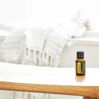 Aceite Esencial Petitgrain dōTERRA 15ml en estante de madera de dormitorio blanco con fondo bokeh