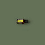 Aceite Esencial Petitgrain dōTERRA 15ml frasco inclinado sobre superficie verde oliva