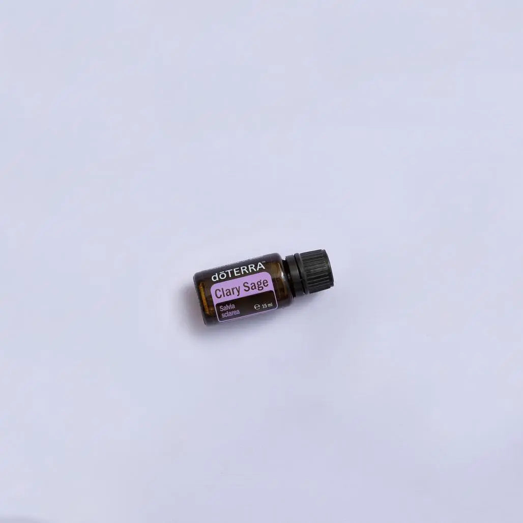 Frasco del Aceite Esencial de Salvia Romana dōTERRA 15ml recostado sobre fondo liso color lavanda, composición minimalista