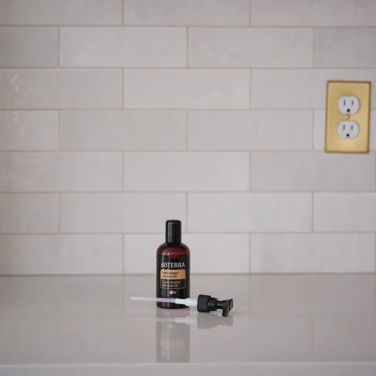 Aceite Fraccionado de Coco dōTERRA 115ml — frasco con botánicas fondo beige