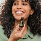 Aceite esencial Mandarina Verde dōTERRA 5ml — mujer sonriendo con frasco a la luz natural