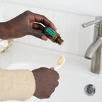 Aceite esencial Supermint dōTERRA 15ml — manos de piel oscura echando una gota en el cepillo de dientes en el baño