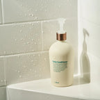 Acondicionador Diario dōTERRA 500ml — mujer aplicando en cabello en la ducha