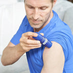 Hombre con polo azul aplicando barra Deep Blue dōTERRA en el hombro en primer plano
