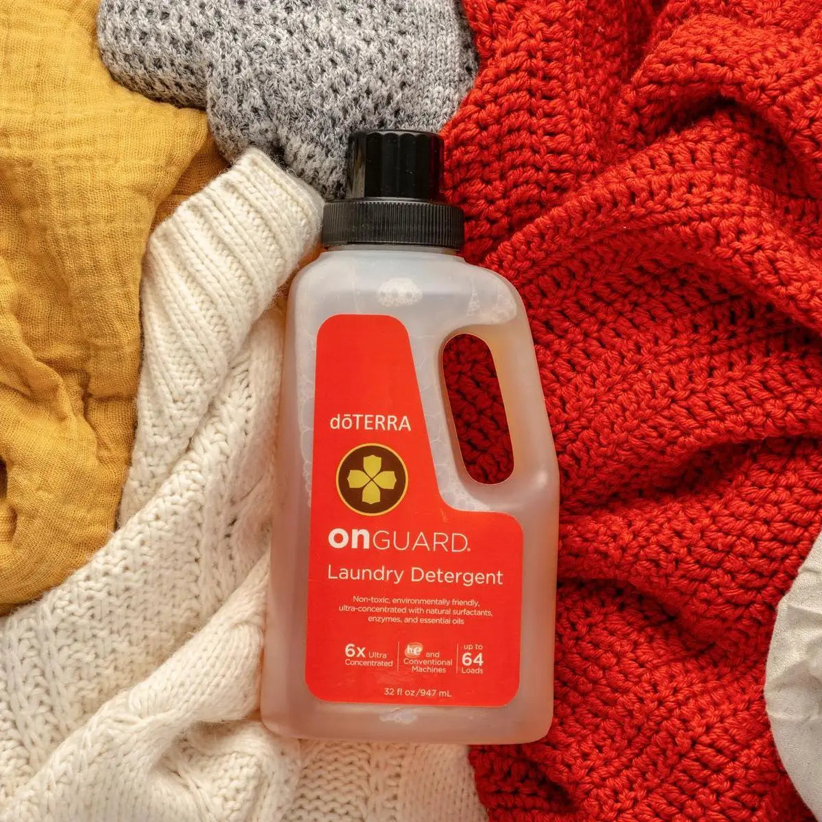 Detergente para lavadora On Guard dōTERRA 947ml — prendas de ropa de colores en vista cenital
