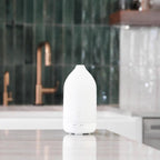 Difusor Laluz dōTERRA blanco en cocina de mármol con grifo de cobre y azulejos verdes