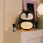 Difusor Penguin doTERRA con aceite esencial Calmer® en mesita de noche infantil
