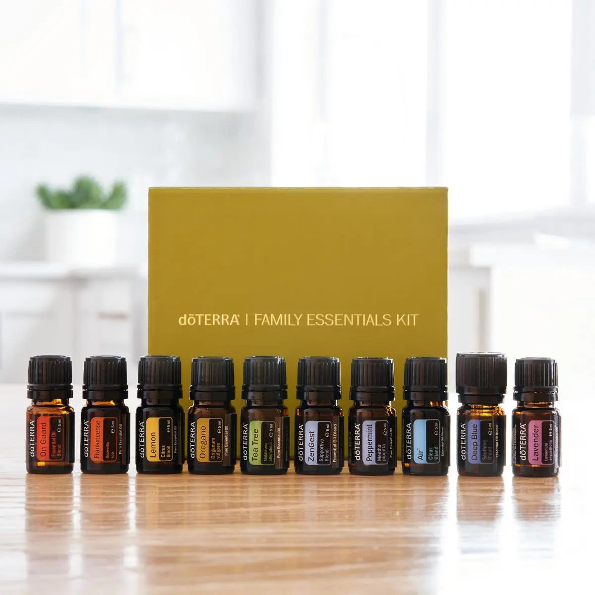 Caja amarilla del dōTERRA Family Essentials Kit con los 10 frascos de aceites esenciales de 5ml alineados en frente.