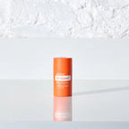 Envase dōTERRA On Guard Stick con Equinácea sobre superficie blanca reflectante y fondo neutro.