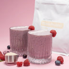 Bolsa de dōTERRA Plant Protein Vanilla junto a dos vasos de batido de frutos rojos con frambuesas y medidor con proteína en polvo.