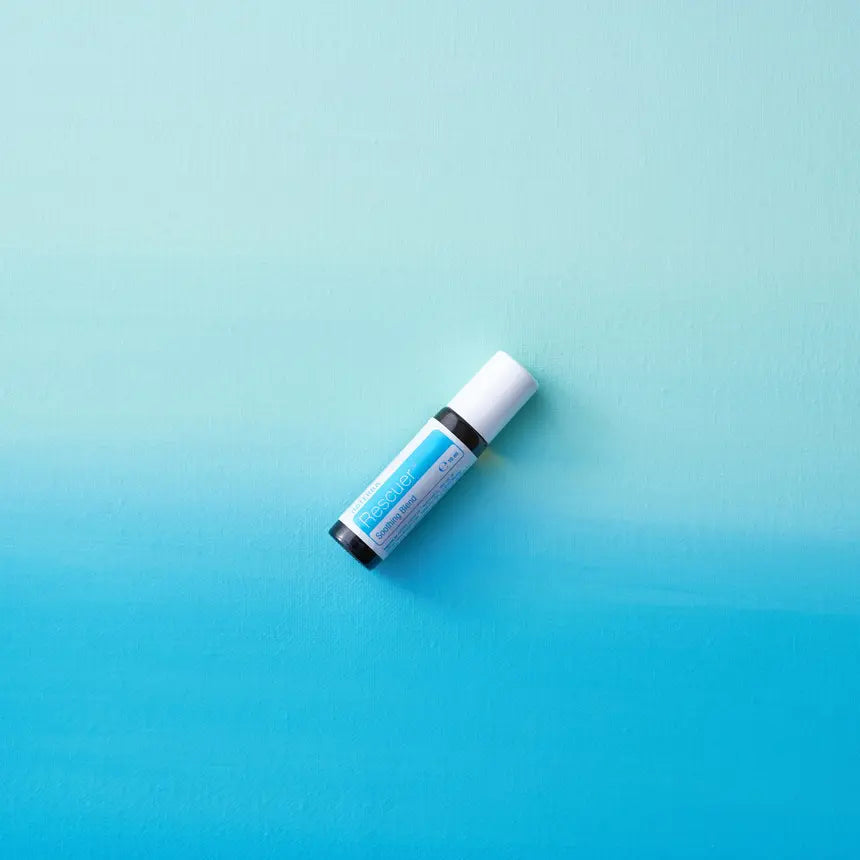 Frasco roll-on dōTERRA Rescuer Touch 10ml dispuesto en diagonal sobre fondo con degradado azul.