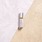 Roll-on de aceite esencial dōTERRA Salubelle Beauty Blend 10ml centrado sobre fondo bicolor lila y beige.