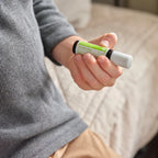 Mano de niño sosteniendo el frasco roll-on dōTERRA Steady Touch de 10ml.