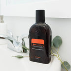 Enjuague bucal On Guard dōTERRA 473ml — frasco sobre encimera de baño con eucalipto