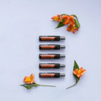 Espray purificador On Guard dōTERRA 27ml — pack de 5 en columna con flores naranjas