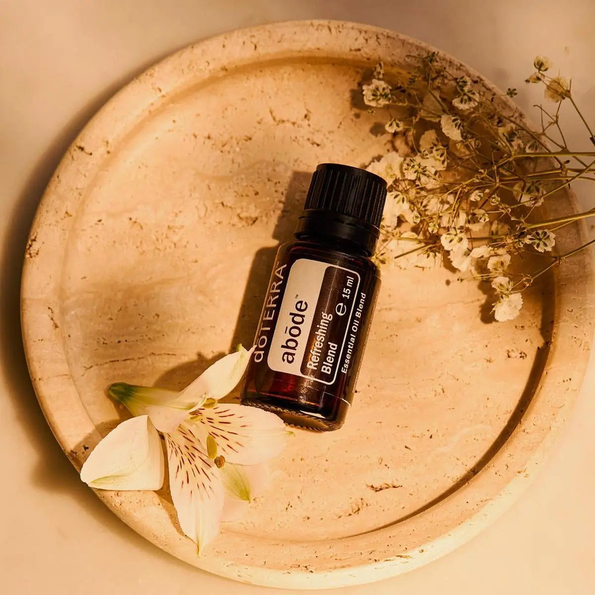 Mezcla Abode dōTERRA 15ml en bandeja terracota con flor blanca y flores secas decorativas