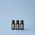 Tres frascos de Mezcla Air dōTERRA 15ml dispuestos sobre fondo azul claro de estudio