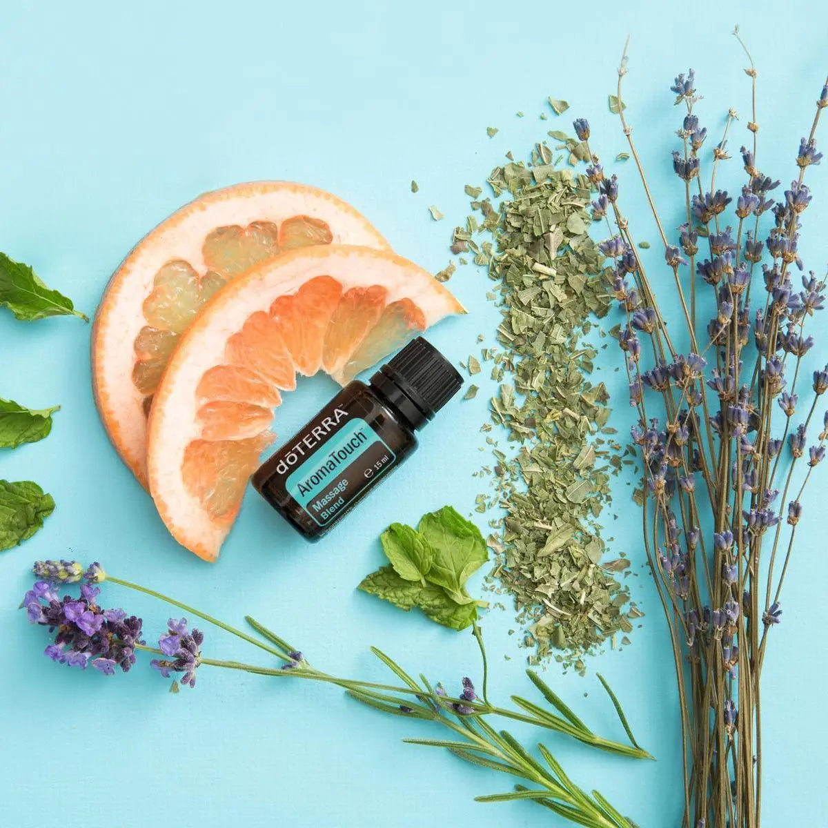 Mezcla dōTERRA AromaTouch 15ml — frasco sobre fondo turquesa con pomelo, lavanda y menta