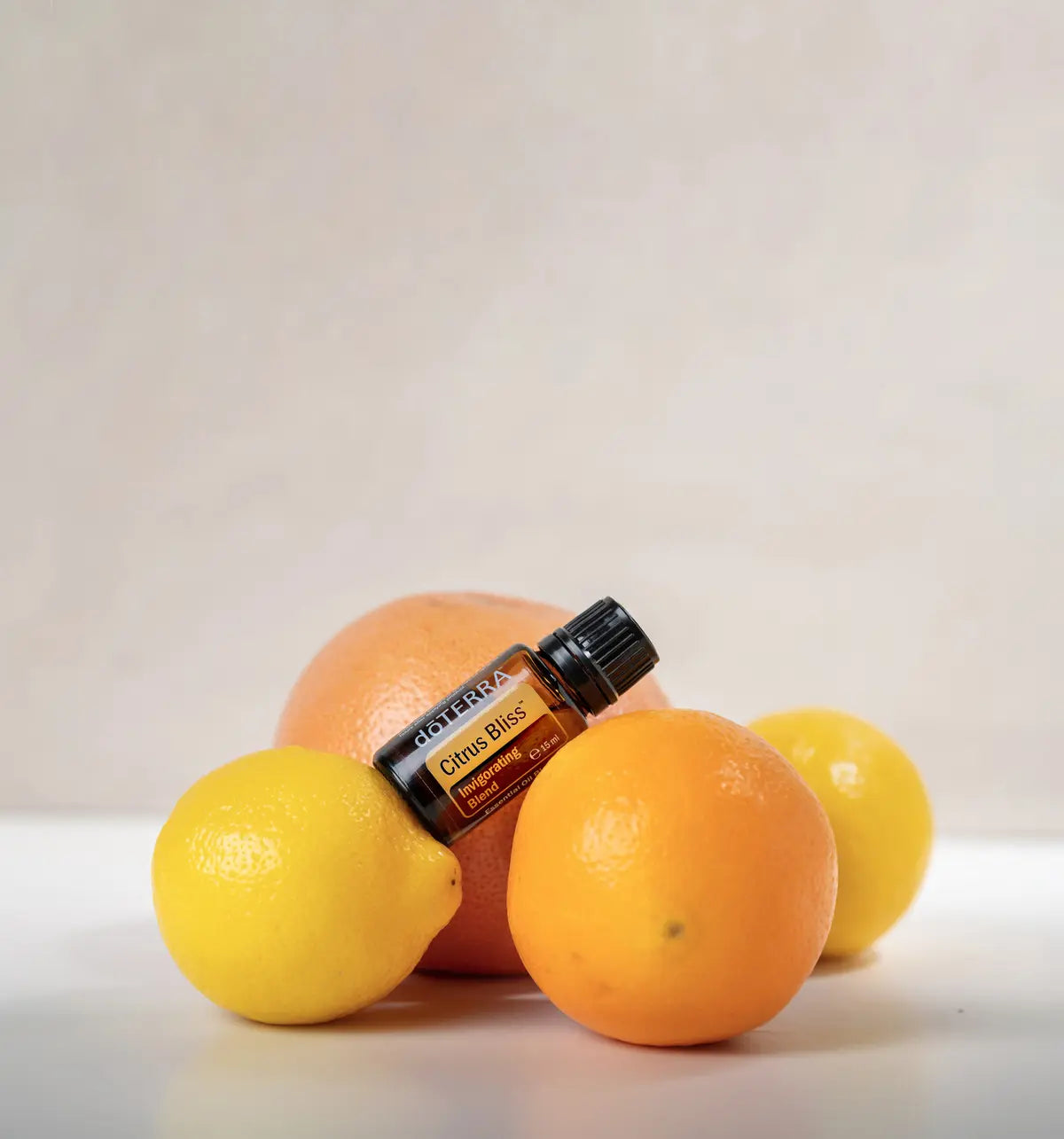 Mezcla dōTERRA Citrus Bliss 15ml — frasco rodeado de cítricos variados sobre fondo beige