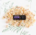 Mezcla dōTERRA Console 5ml — frasco con resina de copal, incienso y ramas verdes, vista cenital