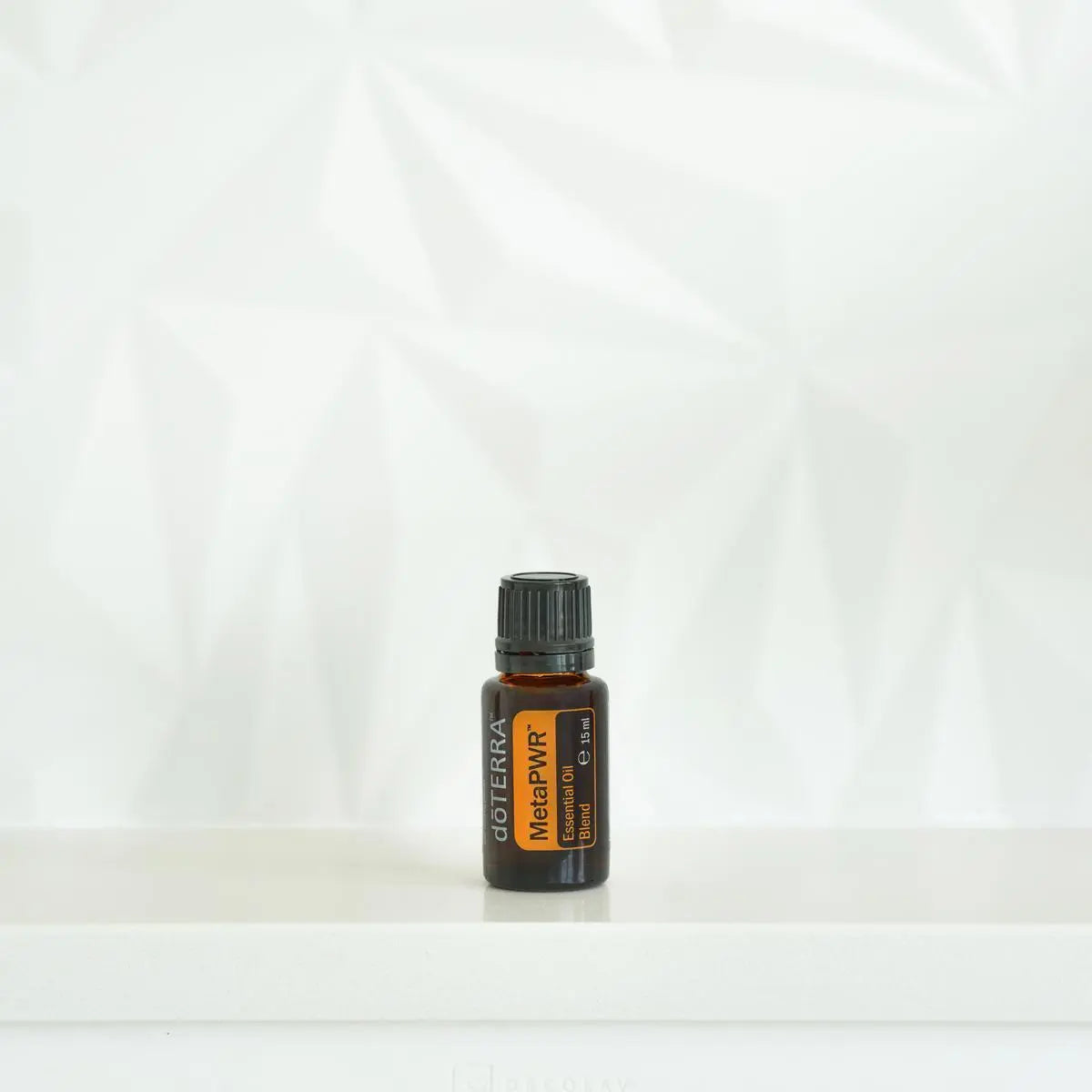 Mezcla dōTERRA MetaPWR 15ml — frasco en estante blanco con sombras de palmera y luz natural