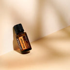 Mezcla dōTERRA MetaPWR 15ml — frasco inclinado en esquina tostada con sombras y luz cálida
