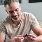 Mezcla dōTERRA Passion 5ml — hombre de pelo canoso sosteniendo el frasco con ambas manos en el salón