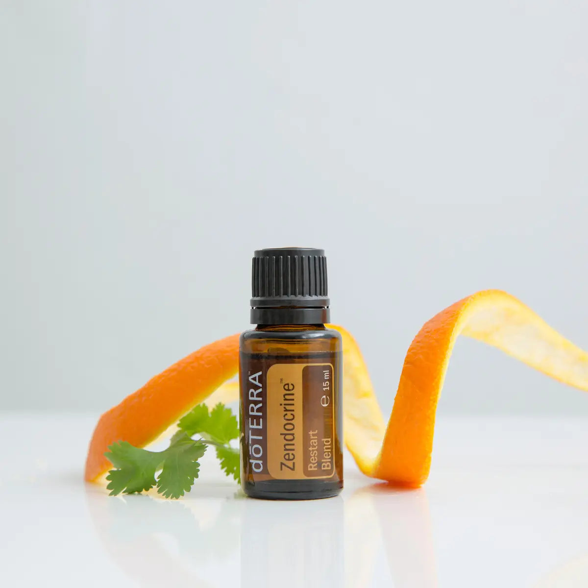 Mezcla dōTERRA Zendocrine 15ml — frasco con espiral de piel de naranja y cilantro sobre fondo blanco