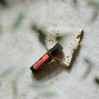 On Guard Touch Roll-On dōTERRA 10ml — sobre fondo verde con hoja