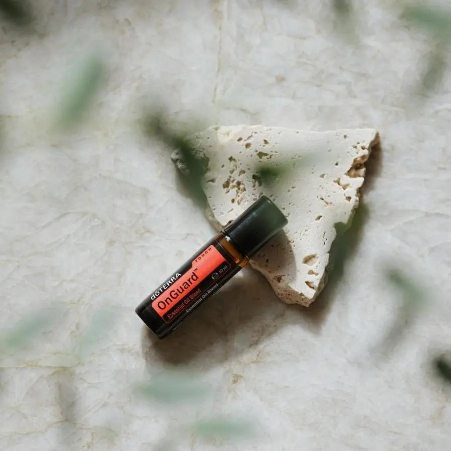 On Guard Touch Roll-On dōTERRA 10ml — sobre fondo verde con hoja