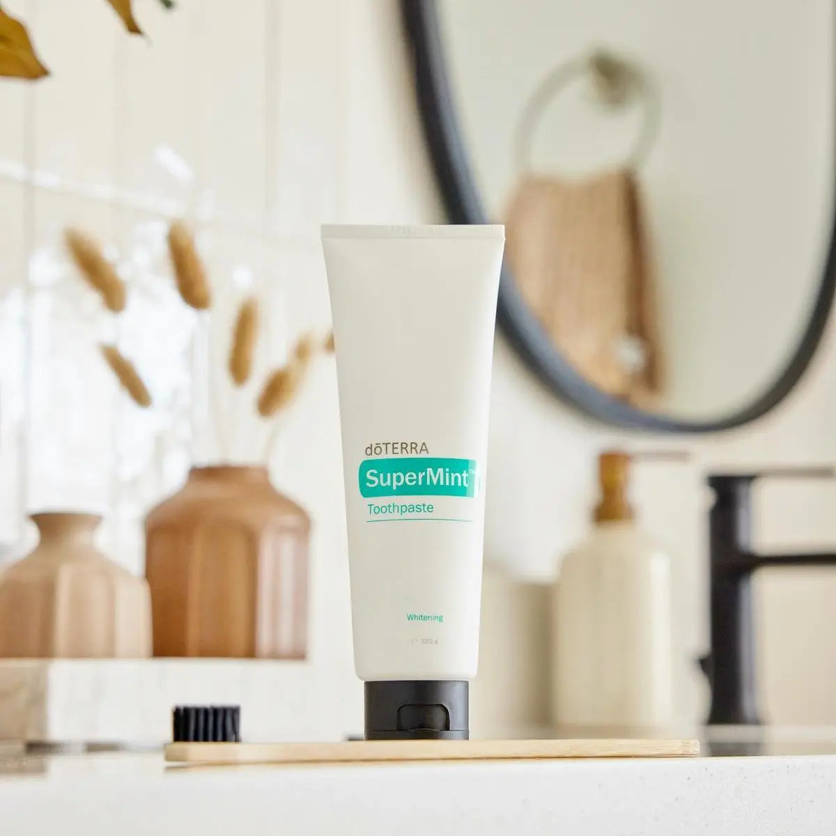 Pasta de dientes SuperMint dōTERRA 125ml — tubo en baño sobre encimera de mármol