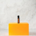Perlas MetaPWR dōTERRA — frasco en cubo naranja vibrante sobre mármol en estudio