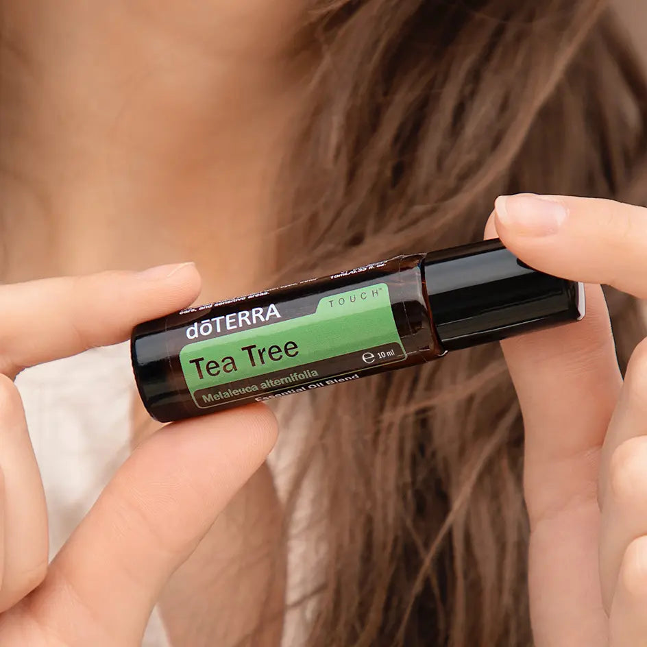 Árbol de Té Touch dōTERRA roll-on 10ml aplicado con manos en el cuero cabelludo