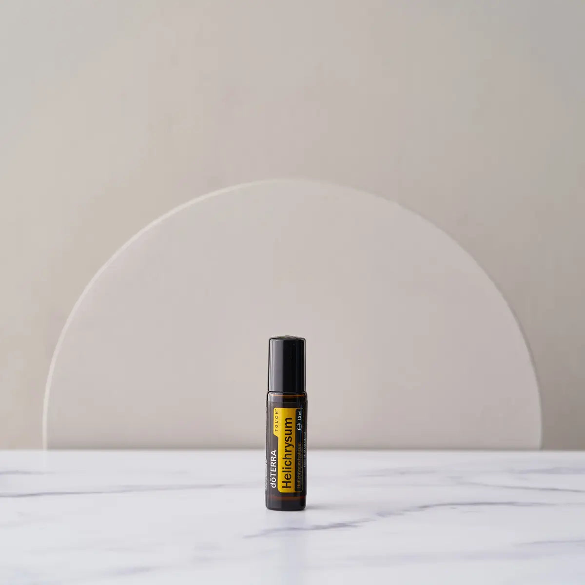 Roll-on Helichrysum Touch dōTERRA 10ml — frasco sobre fondo pastel minimalista
