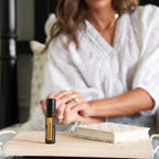 Roll-on Helichrysum Touch dōTERRA 10ml — frasco sobre superficie de mármol con luz natural