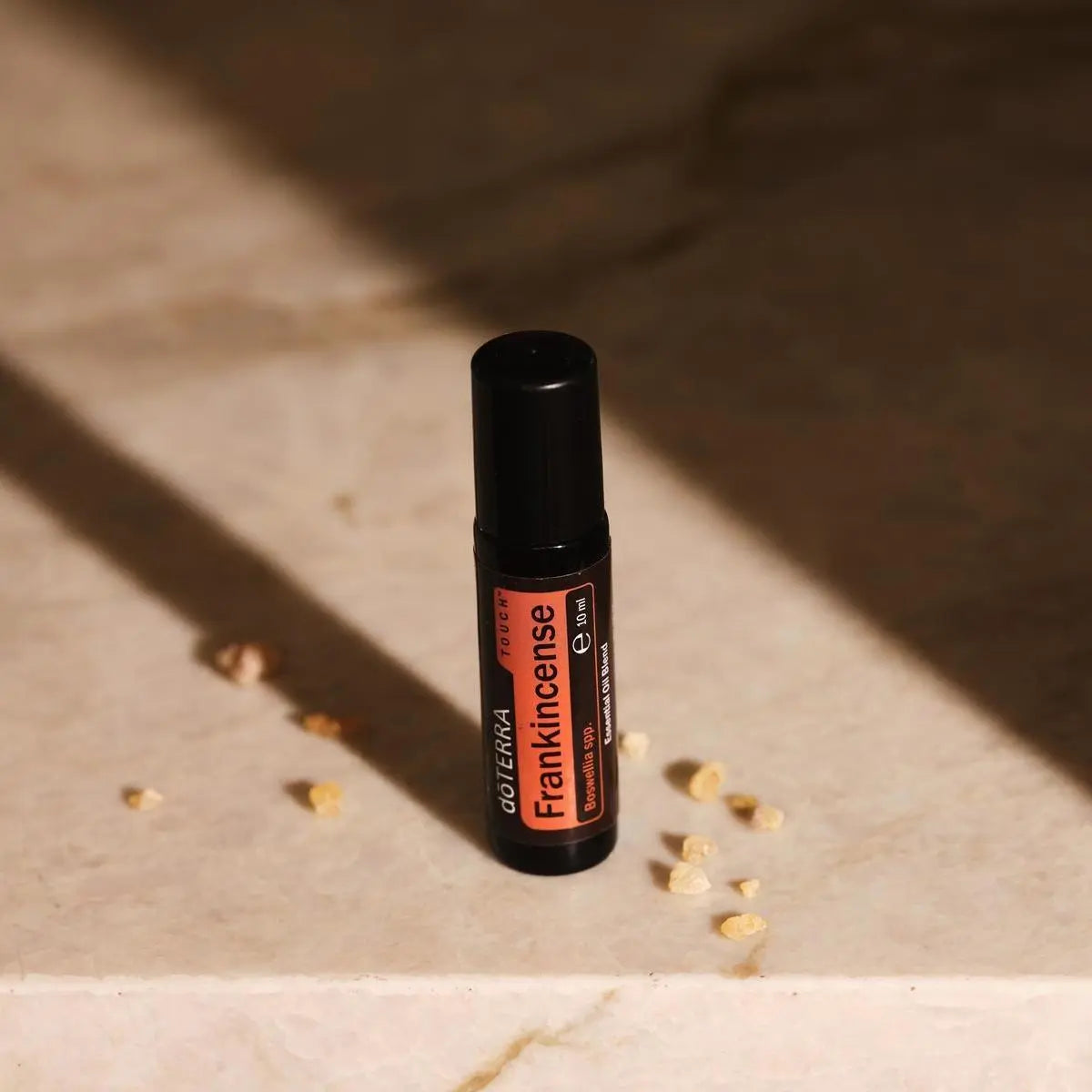 Frankincense Touch dōTERRA 10ml sobre piedra caliza con resina de incienso y luz solar natural