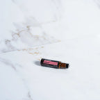 Roll-on InTune Touch dōTERRA 10ml — frasco en estudio con fondo beige