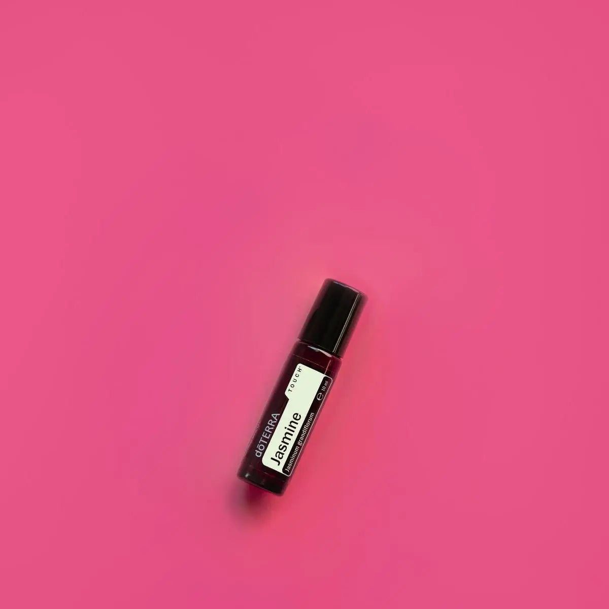 Jazmín Touch dōTERRA 10ml vista cenital sobre fondo fucsia vibrante