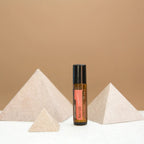 Neroli Touch dōTERRA 10ml junto a pirámides de piedra sobre fondo beige minimalista