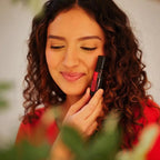 Roll-on Passion Touch dōTERRA 10ml — mujer morena rizada aplicando el roll-on con fondo bokeh