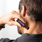 Roll-on PastTense dōTERRA 10ml — hombre aplicando el roll-on en la nuca, primer plano