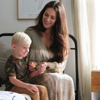Roll-on Thinker dōTERRA 10ml — madre aplicando el roll-on en niño rubio en dormitorio