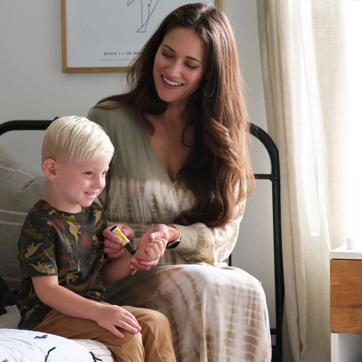 Roll-on Thinker dōTERRA 10ml — madre aplicando el roll-on en niño rubio en dormitorio